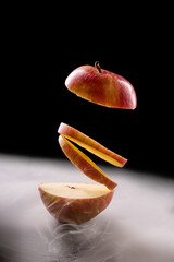 Red apple slices levitating, healthy food concept on black
