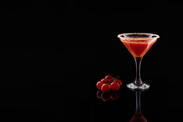 Spicy tomato cocktail with cherry tomatoes on black