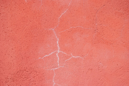 Textura de pared de estuco rojo desgastado con pintura desconchada