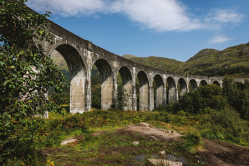 Fototapeta premium Glenfinnan Viaduct railway bridge curving through the green Highland landscape