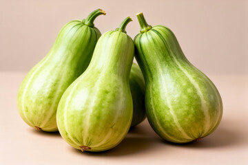 Fresh green bottle gourds with striped skins arranged on peach backdrop evoking farm market vitality and healthy cooking inspiration