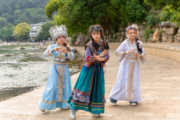 Fototapeta premium Young Chinese women dancing traditional ethnic movements by river