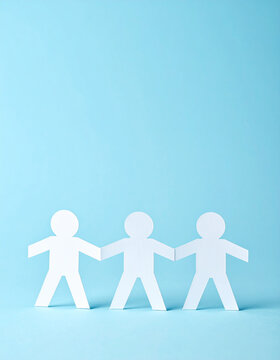 Paper chain cutout people holding hands on blue background, teamwork and helping concept