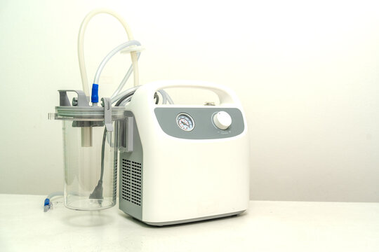 Portable Phlegm Suction on white background, Sputum suction machine from a tube in the throat of a patient who has undergone a tracheostomy surgery in hospital.