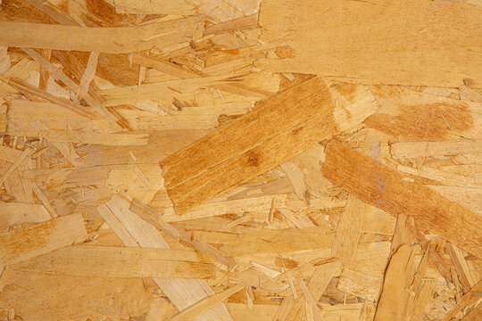 Wooden particle board background with natural OSB texture, recycled timber flakes for eco-friendly design and furniture. Solid wood chipboard pattern ideal for professional backgrounds.