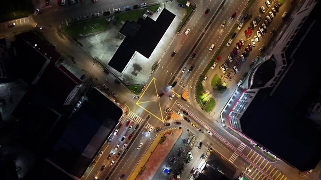 Drone panorama reveals Kota Tinggi night traffic with illuminated roads, clustered cars, and expansive tropical townscape.