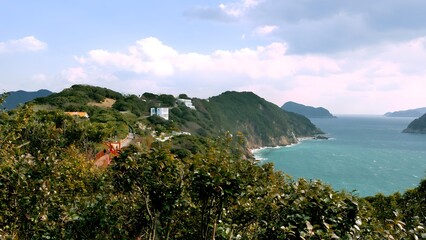 Naklejka premium Scenic coastal landscape with turquoise sea and lush green cliffs.