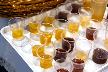 Organic fruit juices in plastic cups served outside on garden party