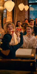 Fototapeta premium Retro women clinking red cocktails under warm pendant lights. Concept of celebration banner design, bar social media content and festive advertising campaign visuals.
