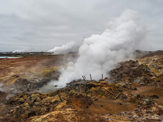 Fototapeta premium Damaged wooden trail in the Gunnuhver Hot Springs. Active geothermal area with volcanic craters, mud pools and steam vents. Möðruvellir, Möðruvallavegur, Reykjanes Peninsula, Iceland.
