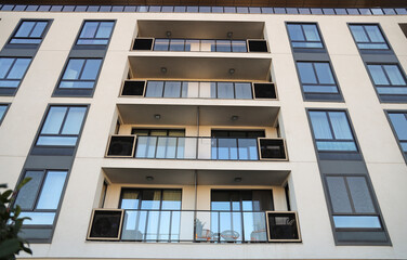 Fototapeta premium Exterior view of a modern apartment building facade with large windows and an air conditioning unit. Ideal for architecture, real estate, urban living, and home improvement concepts. Belgrade on water