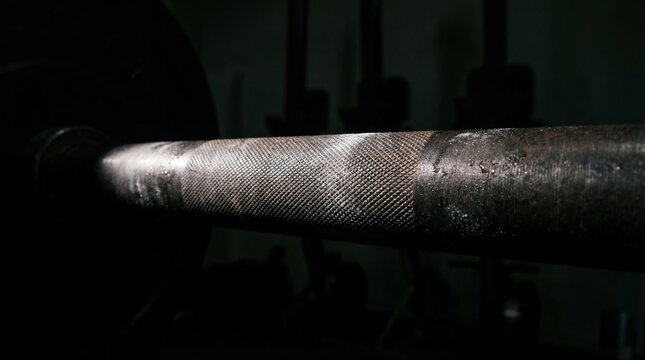 Macro texture of barbell knurling under focused spotlight
