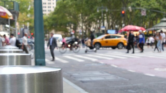Sixth 6 avenue and 42nd street crossroad, Bryant park in Manhattan Midtown, New York City, United States of America. Defocused people pedestrians crossing on zebra near bank, yellow taxi car on road.