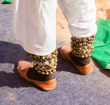 Rajasthani male dancer&rsquo;s legs wearing traditional mojari footwear and full length ghungroo after a folk dance performance. 
