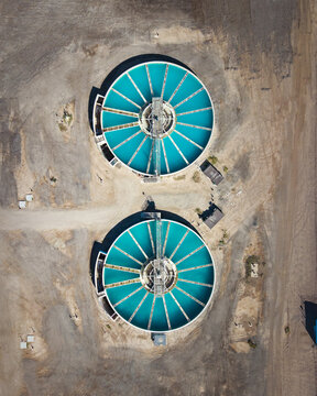Aerial view of turquoise water treatment tanks sit starkly against the arid landscape, a testament to human intervention in the desert, El Centro, California, United States.