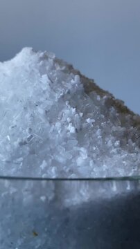 Epsom salts. Salt. A glass. A mountain of salt. Epsom salts. Slow motion video. High quality 4k footage