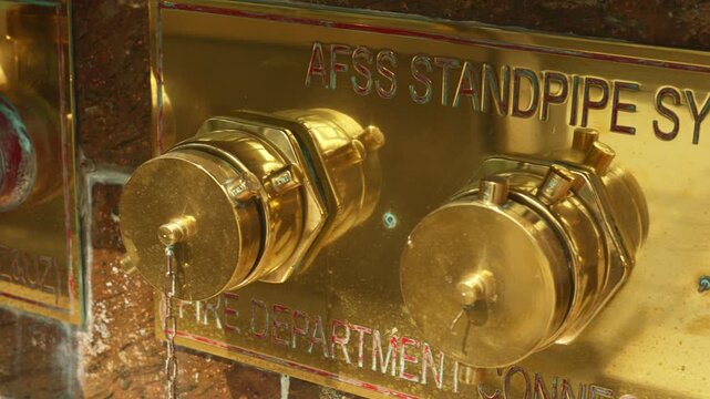 Closeup of industrial pipe fittings, urban safety equipment featuring polished brass and multiple fittings, closeup image of vintage brass piping system with engraved labels and warm patina effects
