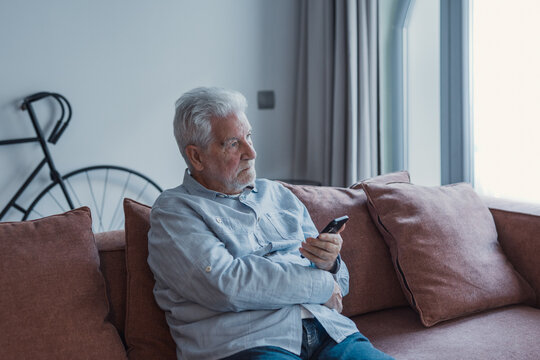 Worried senior smartphone user getting bad, concerning news message, holding mobile phone, looking away, feeling stressed, anxious, thinking over problems, sms answer&nbsp;