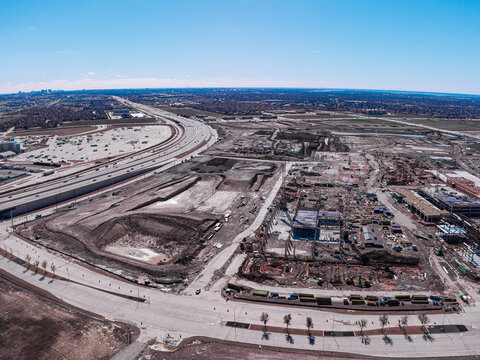 Aerial view of construction site with visible highways and developing infrastructure under a bright sky, Frisco, Texas, United States.