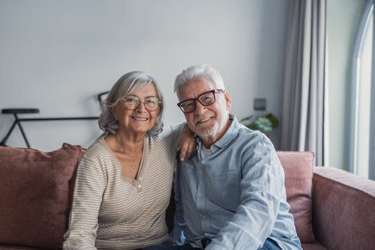 A happy older married couple stands together at home, laughing and hugging with love while enjoying a close relationship built on trust, support, care, and shared joy in a tender lifestyle moment