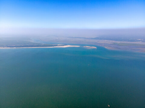 Aerial view of the tranquil water meets the sandy shore under the haze of the skyline, Cox's Bazar, Chittagong Division, Bangladesh.