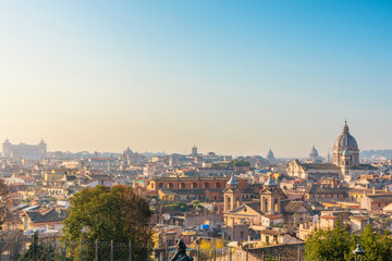 Obraz premium Rome city skyline with historic domes and building rooftops at sunrise, Italy. Urban landscape with Italian architecture. Popular travel and touristic destination in Europe