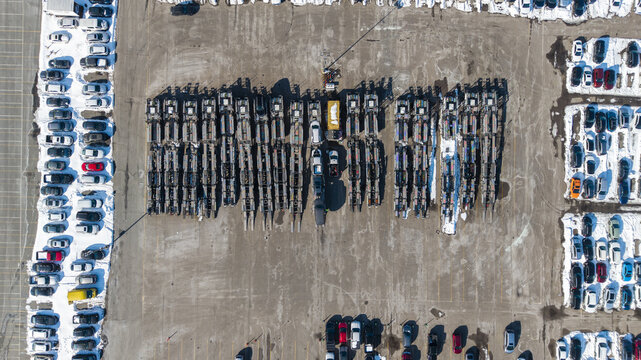 Aerial view of parked vehicles casting long shadows on a cold winter day, snow lining the edges of the lot, Framingham, Massachusetts, United States.