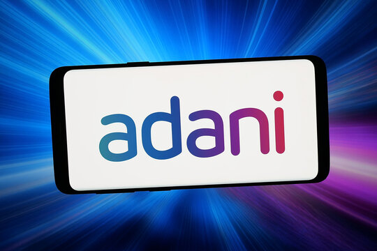 Stuttgart, Germany - 02-20-2026: In this photo illustration, the logo of Indian business conglomerate Adani Group is displayed on a smartphone in front of abstract background on computer screen.