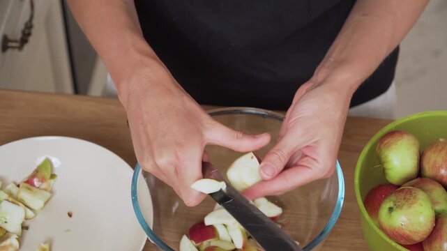 Cutting apple quarters removing seeds preparing homemade compote. Cleaning fruit pieces trimming core before adding to traditional drink. Slicing apple chunks refining ingredient for sweet homemade