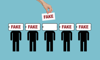 Hand placing Fake label on a digital person's head - Concept of misinformation and deepfakes