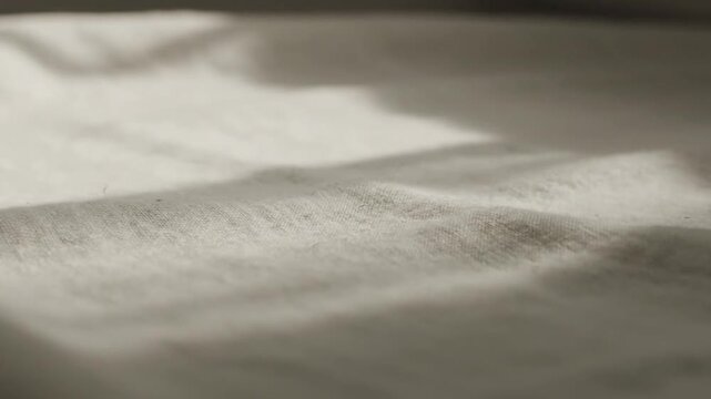 Soft White Fabric Texture with Gentle Sunlight Shadows, Close-up Macro Shot