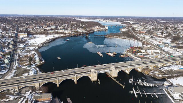 Aerial view of a bridge cutting across the Seekonk River, with patches of ice and snow contrasting with the dark water, Providence, Rhode Island, United States.