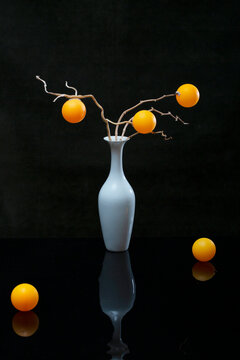 Still life with white and orange balls and white vase
