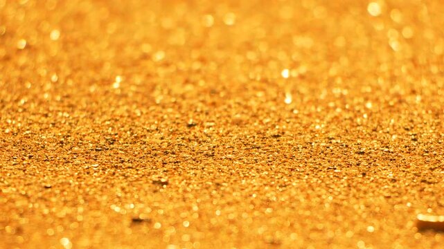 Gold texture glitter sparkling background macro shot of illuminated golden sand grains creating abstract shiny pattern