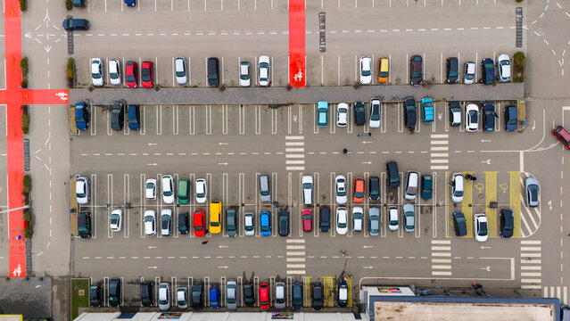 Aerial view of rows of parked cars in a lot marked by red pedestrian zones and white crosswalks, Sremska Mitrovica, Vojvodina, Serbia.