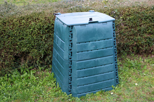 Bac composteur en plastique vert dans le jardin