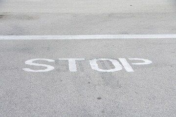 white stop sign word painted on road surface