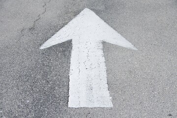 white arrow painted on asphalt street close up