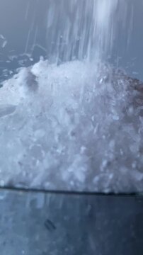 Epsom salt. Glass. Salt spills out. Salt is pouring. Slow motion video. High quality 4k footage