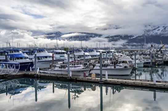 Boats in harbor, cloudy mountain peaks behind, with reflection, Seward, Kenai Peninsula, Alaska, USA