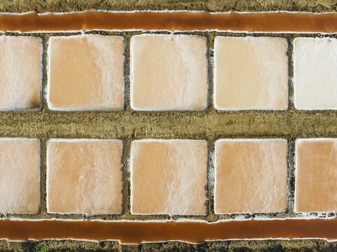 Saline ponds at the salt works near Chiclana de la Frontera. The orange-red colour depends on the level of salinity and is directly caused by the algae Dunaliella salina and brine shrimp. Aerial view. Drone shot. C&aacute;diz province, Andalusia, Spain