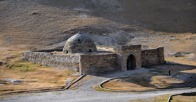 Historic caravanserai Tash Rabat from the 15th century, with yellow hills, Atbashy district in the Naryn region, Kyrgyzstan