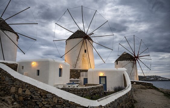 Illuminated windmills, Kato Milli, at sunset, dramatic cloudy sky, Mykonos Town, Mykonos, Greece