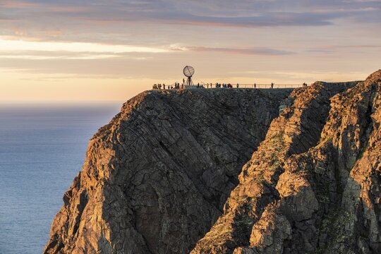 Rock cliff of the North Cape with steel globe at midnight sun, Nordkapp, Finnmark, Norway