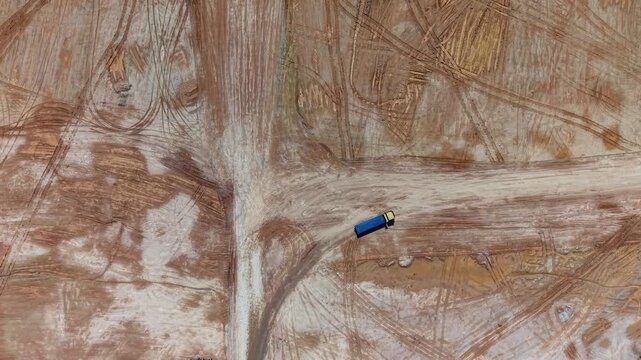 Aerial view of construction site with trucks and tire tracks