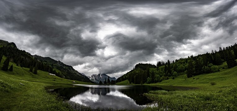 Gr&ouml;ppelensee with reflection of the Altmann summit in the background under a threatening cloudy sky, Wildhaus, Appenzell, Switzerland
