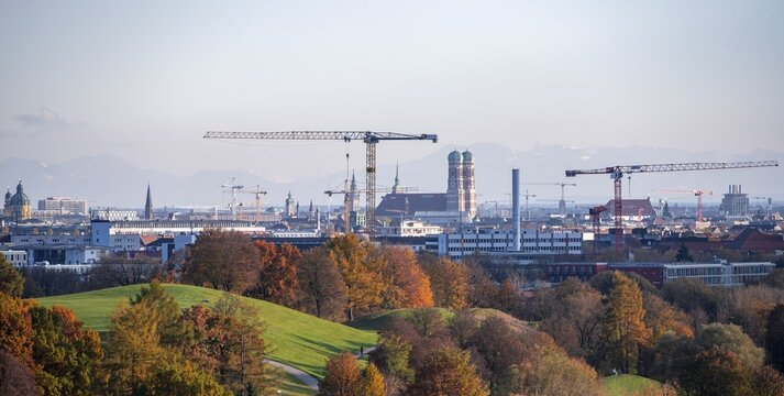 Autumn trees in the Olympic Park, cityscape with Church of Our Lady and mountains in the background, view from the Olympic Stadium, Olympic Park, Munich, Bavaria, Germany