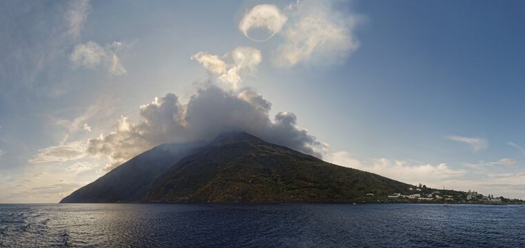 Stromboli volcano and island with the small fishing village of San Vincenzo with a circular smoke ring, Stromboli, Calabria, Italy