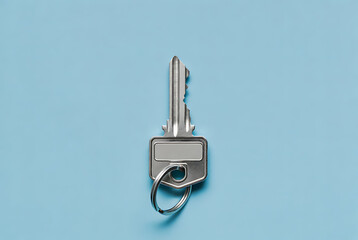 Key metal house key with keyring and blank label tag isolated on blue background, minimal flat lay concept for security, access, rental, property and locksmith services