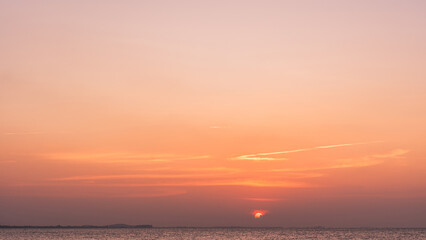 Obraz premium Sunrise sky cloud over sea water background in morning with orange, yellow sun light,Horizon sunset sea ocean sunset sky landscape nature backgrounds and gold sun down in golden hour season,Dusk